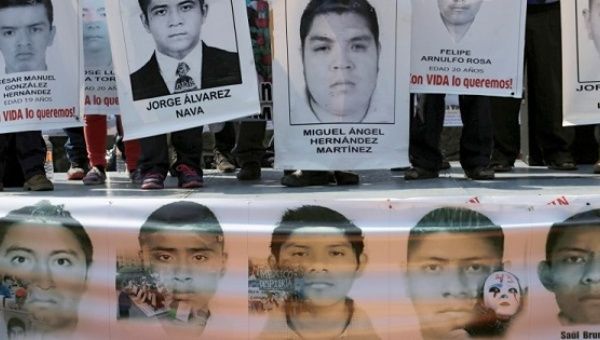 Relatives hold up posters in support of 43 disappeared students from the Ayotzinapa teacher training college during a rally in Mexico City, Feb. 19, 2015.