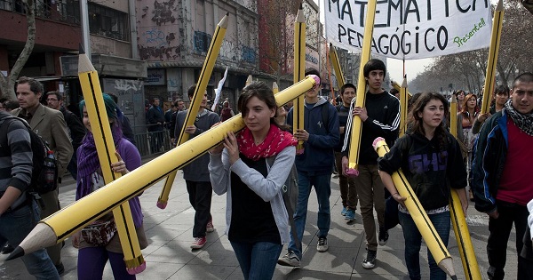 Students with giant pencils march in Santiago, Chile, to demand better quality public education.