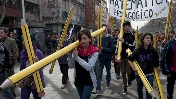 Students with giant pencils march in Santiago, Chile, to demand better quality public education.