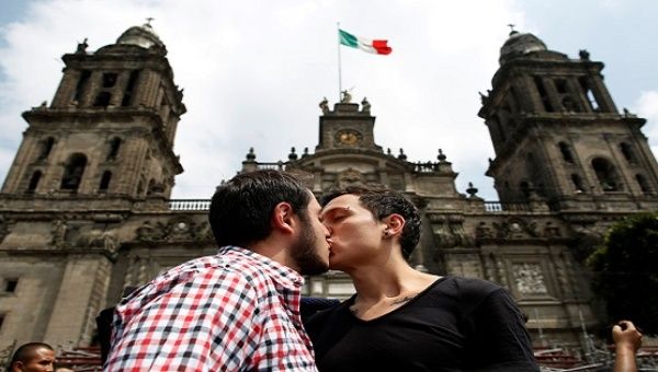 A couple kiss each other in front of the cathedral during a march in support of gay marriage, sexual and gender diversity in Mexico City on September 11, 2016.