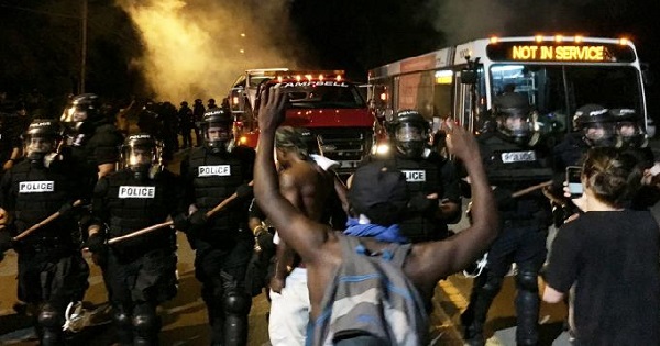 Police officers block a road during protests after police fatally shot Keith Lamont Scott in the parking lot of an apartment complex, Sept. 20, 2016.