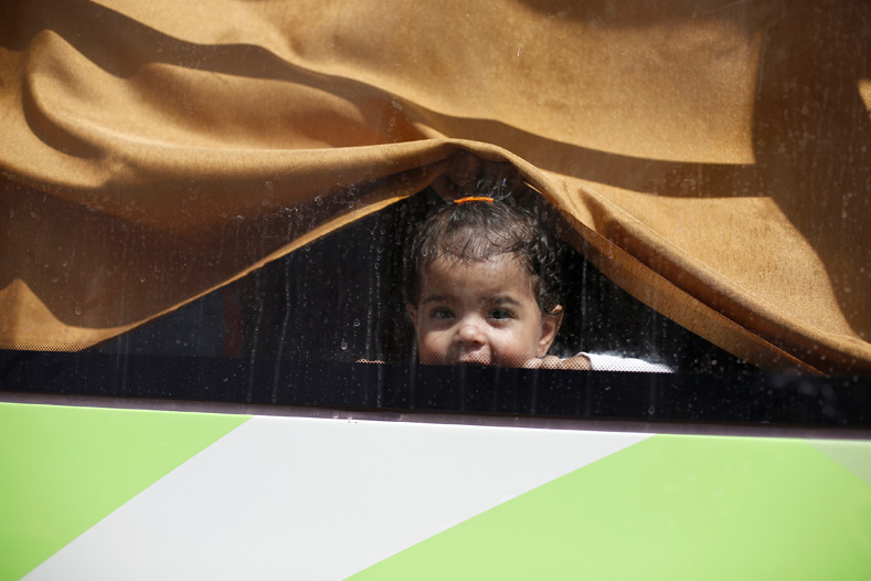 A child, a relative of a rebel fighter, rides a bus to evacuate the besieged Waer district in the central Syrian city of Homs, after a local agreement reached between rebels and Syria's army, Syria Sept. 22, 2016. 