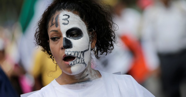 A woman takes part in a march in Mexico City, with a 43 on her face referring to the missing students of Ayotzinapa.