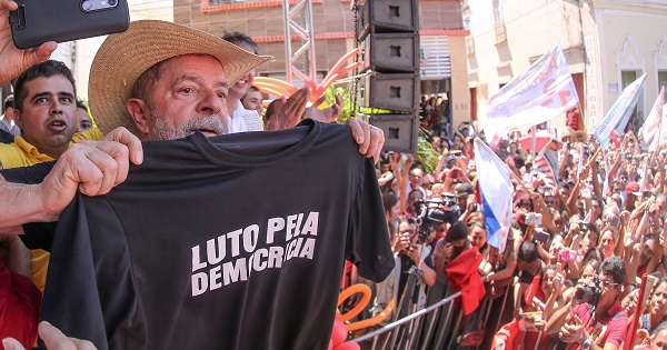 Brazil's former President Lula da Silva holds a t-shirt that says 