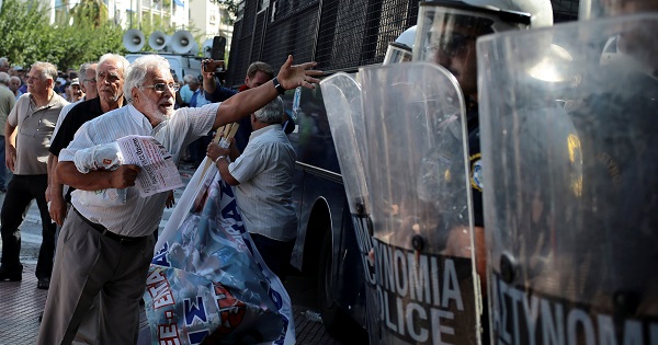 A Greek pensioner shouts at riot police following scuffles during a demonstration against planned pension cuts, Athens, Greece, Oct. 3, 2016.