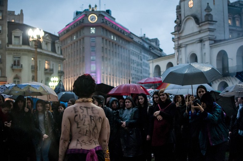 In Argentina, a woman stands topless with the message 