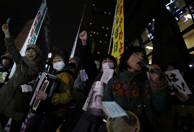 Protesters rising their fists shout slogans during an anti-nuclear rally in front of the headquarters of Tokyo Electric Power Co (TEPCO), the operator of the tsunami-crippled Fukushima Daiichi nuclear plant, a day before the five-year anniversary of the disaster, in Tokyo, Japan, March 10, 2016.