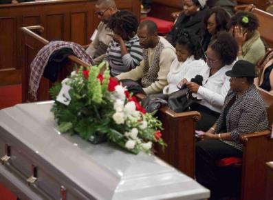 The stepfather and mother (C) of Akai Gurley attend his wake at Brown Memorial Baptist Church in Brooklyn, New York Dec. 5, 2014.