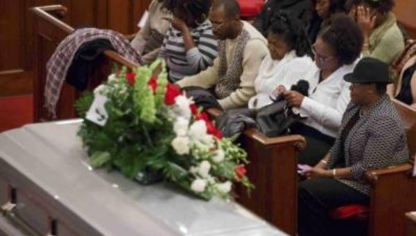 The stepfather and mother (C) of Akai Gurley attend his wake at Brown Memorial Baptist Church in Brooklyn, New York Dec. 5, 2014.