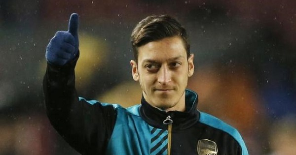 Arsenal's Mesut Ozil warms up ahead of a match against F.C. Barcelona at the Camp Nou on 16/3/16.