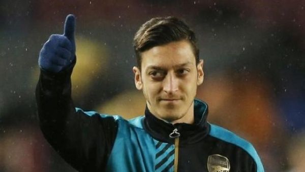 Arsenal's Mesut Ozil warms up ahead of a match against F.C. Barcelona at the Camp Nou on 16/3/16. 