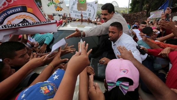 Venezuela President Nicolas Maduro greets supporters as he arrives for his weekly broadcast in La Victoria, Venezuela Nov. 20, 2016. 