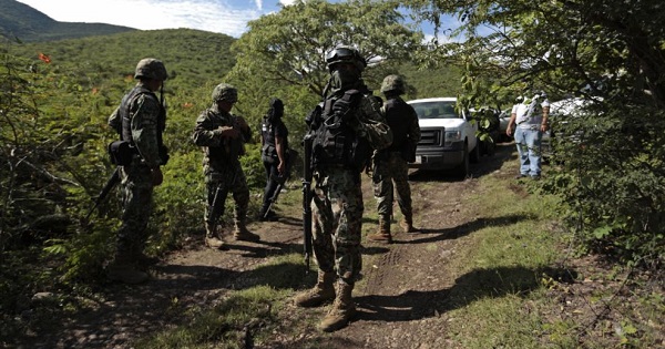 This file photo show Mexican soldiers guarding an area where a mass grave was found, in Colonia las Parotas on the outskirts of Iguala, in Guerrero, Mexico.