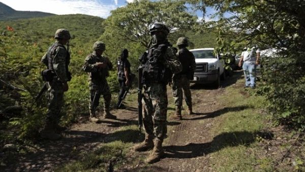 This file photo show Mexican soldiers guarding an area where a mass grave was found, in Colonia las Parotas on the outskirts of Iguala, in Guerrero, Mexico.