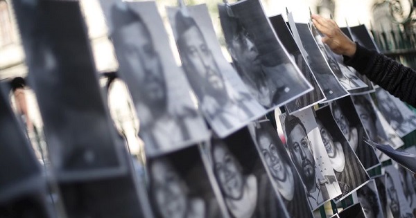 A man hangs images of murdered journalists during a demonstration against the murder of a journalist in Mexico City.