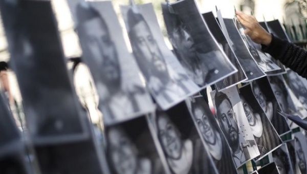 A man hangs images of murdered journalists during a demonstration against the murder of a journalist in Mexico City.