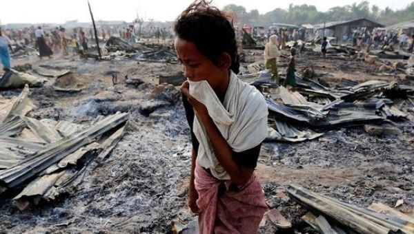 A woman walks among debris after fire destroyed shelters at a camp for internally displaced Rohingya Muslims in Rakhine State near Sittwe, Myanmar May 3, 2016.