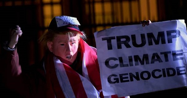 A man wearing a Donald Trump mask protests during a demonstration against climate change outside of the U.S. Embassy in London.
