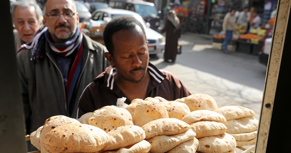 Men queue to buy bread at a bakery in Cairo.