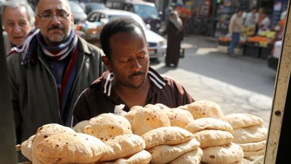 Men queue to buy bread at a bakery in Cairo.