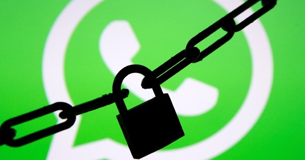 A photo illustration shows a chain and a padlock in front of a displayed Whatsapp logo.