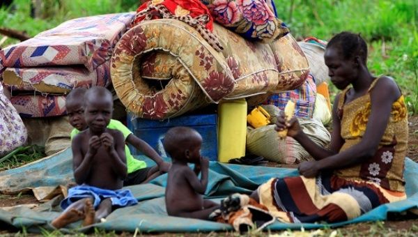 A woman displaced by fighting in South Sudan rests by her belongings in Lamwo after fleeing fighting in Pajok town across the border in northern Uganda.