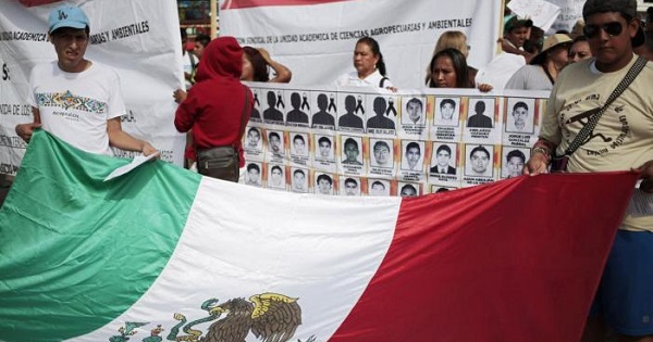 People hold a Mexican flag during a demonstration to demand information on the 43 missing students of the Ayotzinapa teachers' training college.