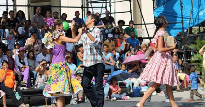 Dancer-actors perform a scene on stage.