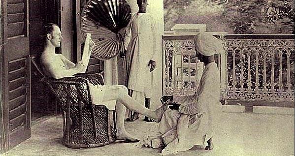 A British man gets a pedicure from an Indian servant.