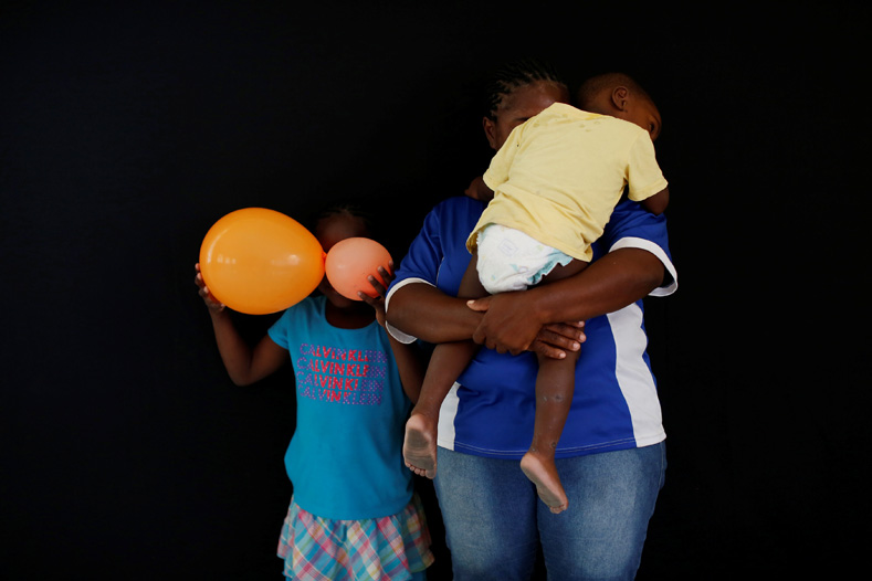 A woman from Honduras who didn't want to be identified and who is hoping to get refugee status in Mexico, poses for a photograph with her children at a migrant shelter, known as The 72, in Tenosique, Tabasco, Mexico, April 12, 2017. 