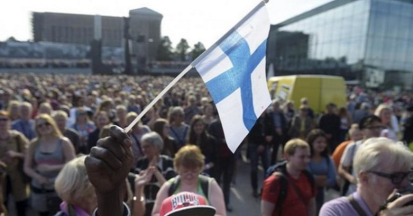 Mire Ibrahim waves the Finnish flag during a demonstration against racism where an estimated 15,000 people attended in Helsinki, Finland on July 28th, 2015.