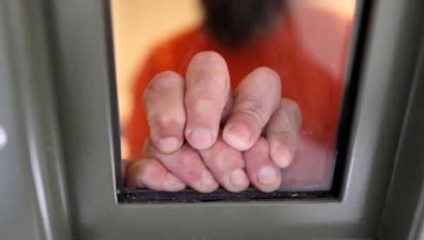 An ICE detainee rests his hands on the window of his cell in the segregation wing at the Adelanto immigration detention center in California, April 13, 2017.