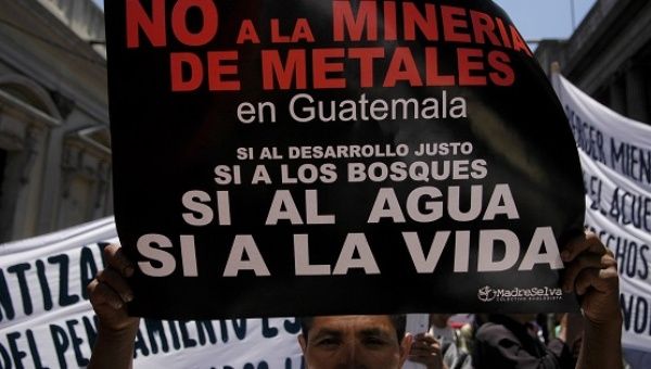 A demonstrator carries a sign protesting metals mining in Guatemala in defense of water and life in Guatemala City in 2006.