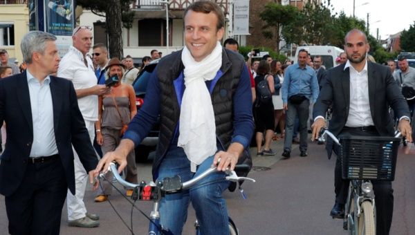 French President Emmanuel Macron rides a bicycle in Le Touquet, France, on the eve of the first round of the parliamentary election, June 10, 2017.