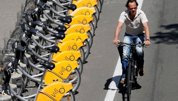 A man rides a bike near parked self-service public bicycles in Brussels, Belgium, on June 14, 2017. 