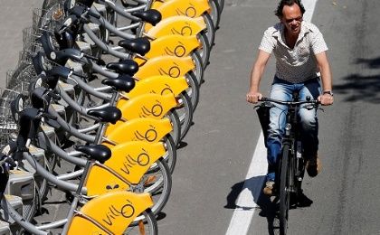 A man rides a bike near parked self-service public bicycles in Brussels, Belgium, on June 14, 2017. 