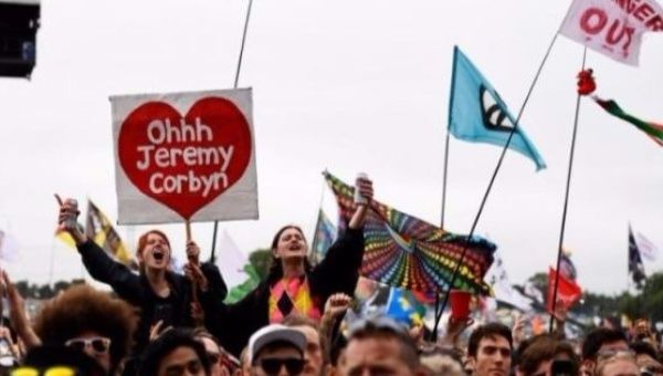 Music fans listen as Jeremy Corbyn, the Leader of the Labour Party, addresses the crowd from the Pyramid Stage during the Glastonbury Festival.