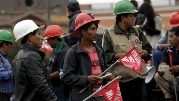 Miners hold signs during a national strike in Lima, Peru, May 21, 2015.