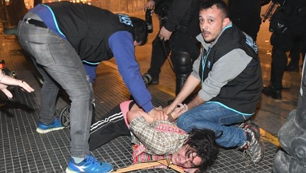 Argentine police arrest a protester during a march in Buenos Aires demanding the appearance of Santiago Maldonado.