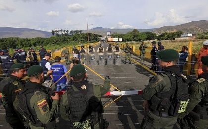 Colombian policemen stand guard in front of the border with Venezuelan policemen near Villa del Rosario village.