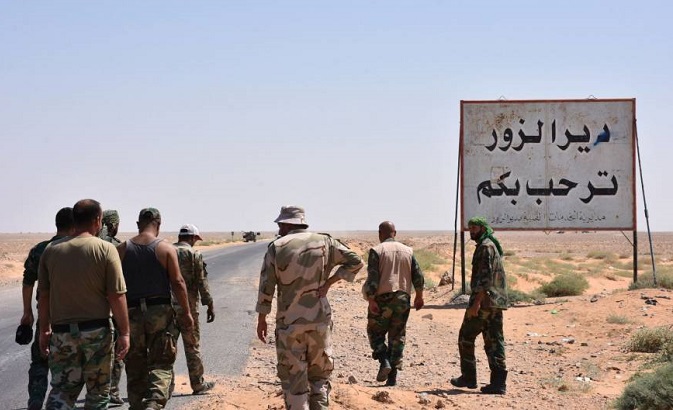 Members of the Syrian Arab Army stand at the entrance to the area around Deir ez-Zor just before breaking the seige. The writing in Arabic reads: 'Welcome to Deir Ezzor.