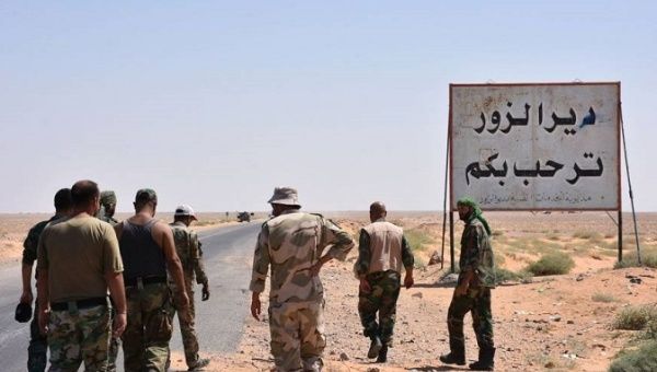 Members of the Syrian Arab Army stand at the entrance to the area around Deir ez-Zor just before breaking the seige. The writing in Arabic reads: 'Welcome to Deir Ezzor.