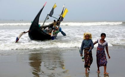 Rohingya refugees walk to the shore after crossing the Bangladesh-Myanmar border by boat through the Bay of Bengal in Teknaf, Bangladesh. 