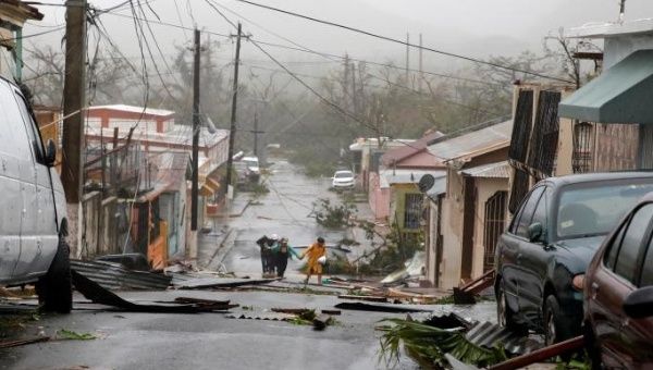 People survey the debris after the streets were hit by Hurricane Maria's winds and rains in Guayama, Puerto Rico 