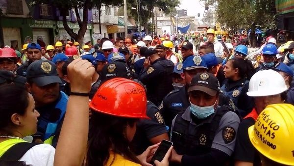 Authorities and volunteers face off as police attempt to seize equipment from those assisting recovery efforts at the collapsed factory at Bolivar & Chimalpopoca.
