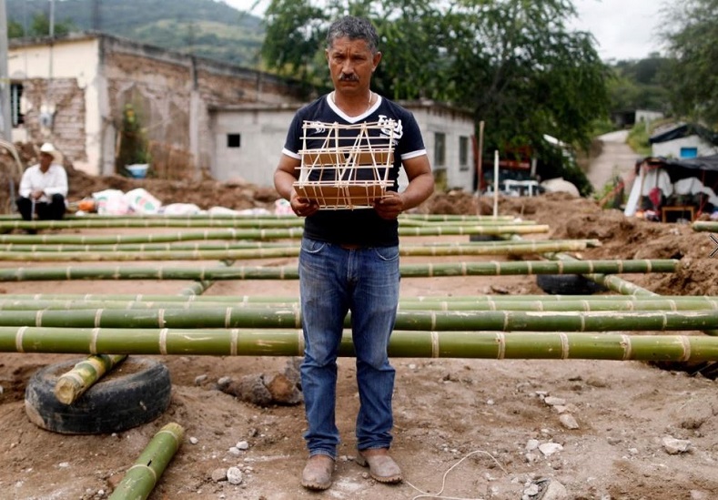 Hector Guzman, 48, a farm worker and representative of the Municipal President in San Jose Platanar, hold the model of a new house for his father.