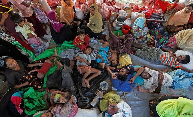 Rohingya refugees who crossed the border from Myanmar this week take shelter under a tent.