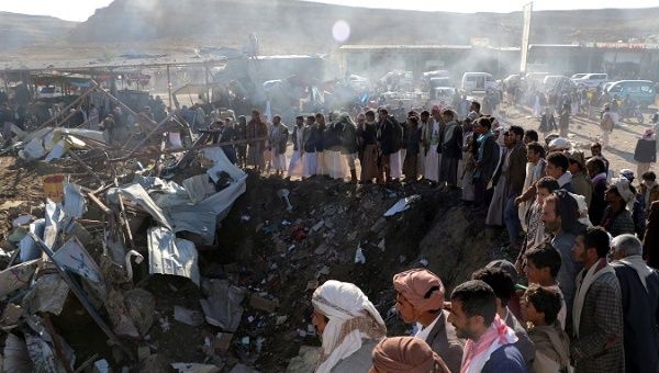 People gather at the site of an air strike in the northwestern city of Saada, Yemen.