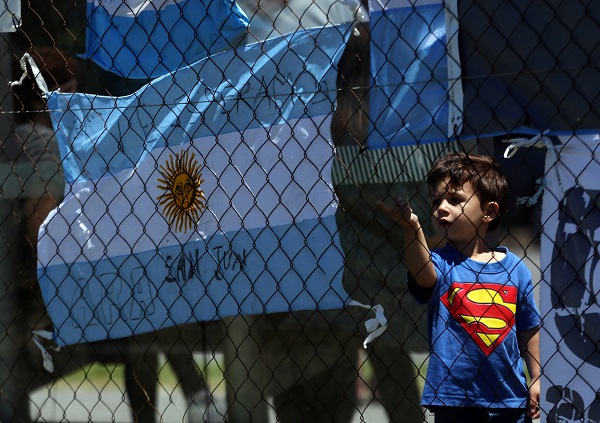 A boy stands next to an Argentine national flag with a message in support of the 44 crew members of the missing ARA San Juan submarine.