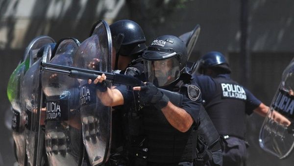 Police officers take aim at demonstrators during pension reform protests in Argentina on December 18.
